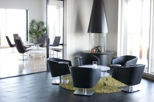 Vio konformad eldstad placerat längs med en vägg i en ljus lounge.