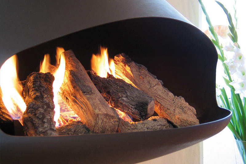 Inzoomning på en brinnande eld med keramisk ved i en modern befintlig öppen spis